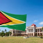 Guyana's Golden Arrowhead flag flies in front of the Parliament Building in Georgetown